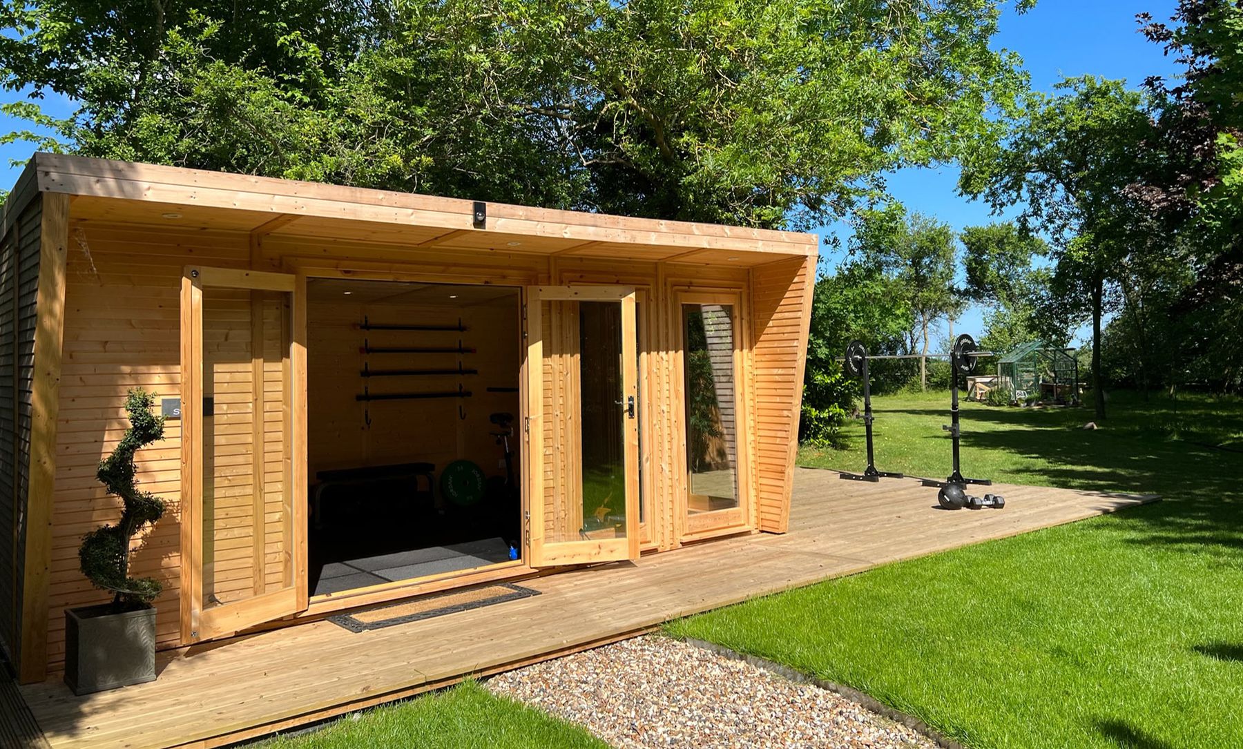 The wooden garden fitness studio surrounded by lawn and trees